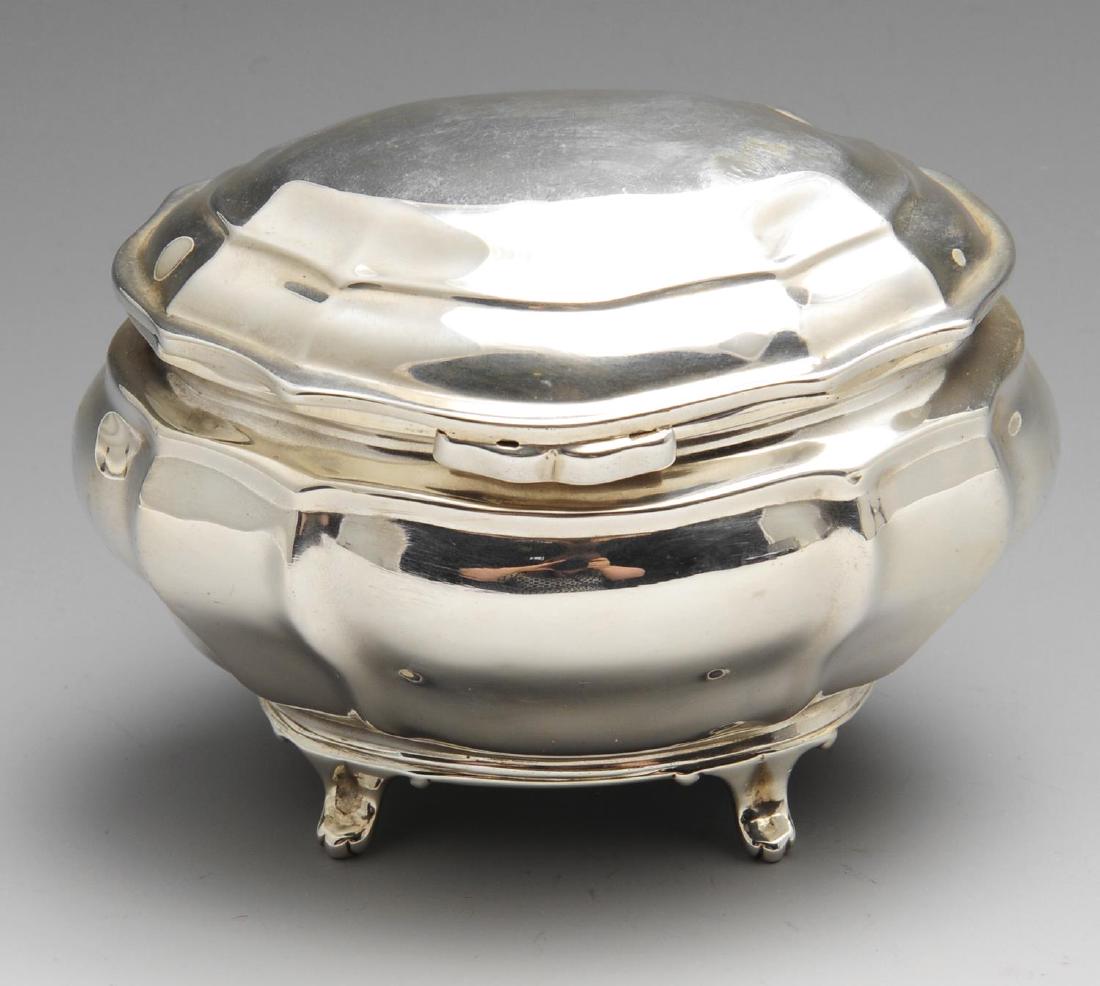 A small Edwardian silver tea caddy, of squat bombe form: A small Edwardian silver tea caddy, of squat bombe form with similarly shaped hinged lid and raised upon four feet. Hallmarked Charles Stuart Harris, London 1902. Height measuring 3 2/8 inches (8.3 cm