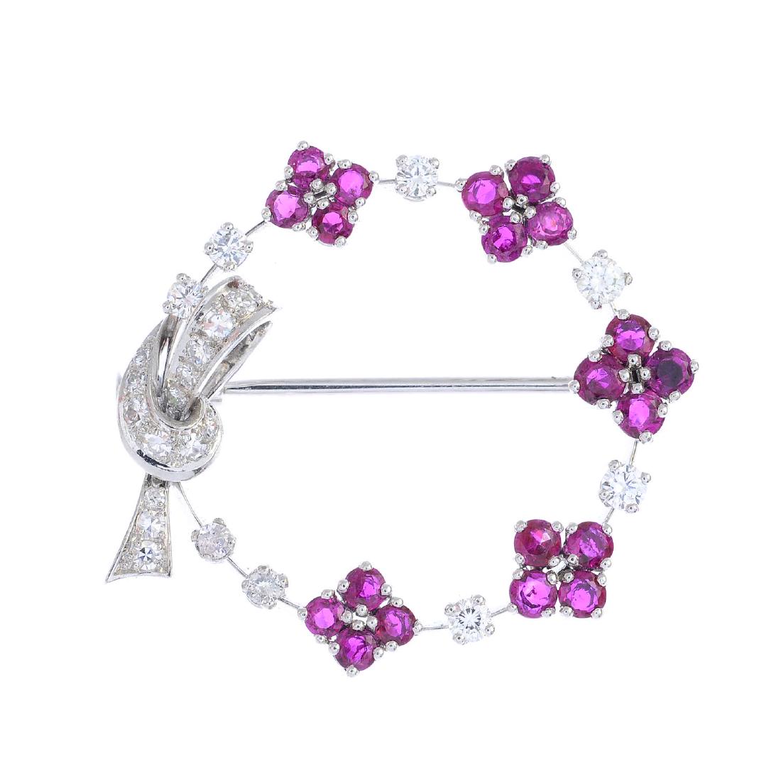 A ruby and diamond brooch. Designed as a graduated