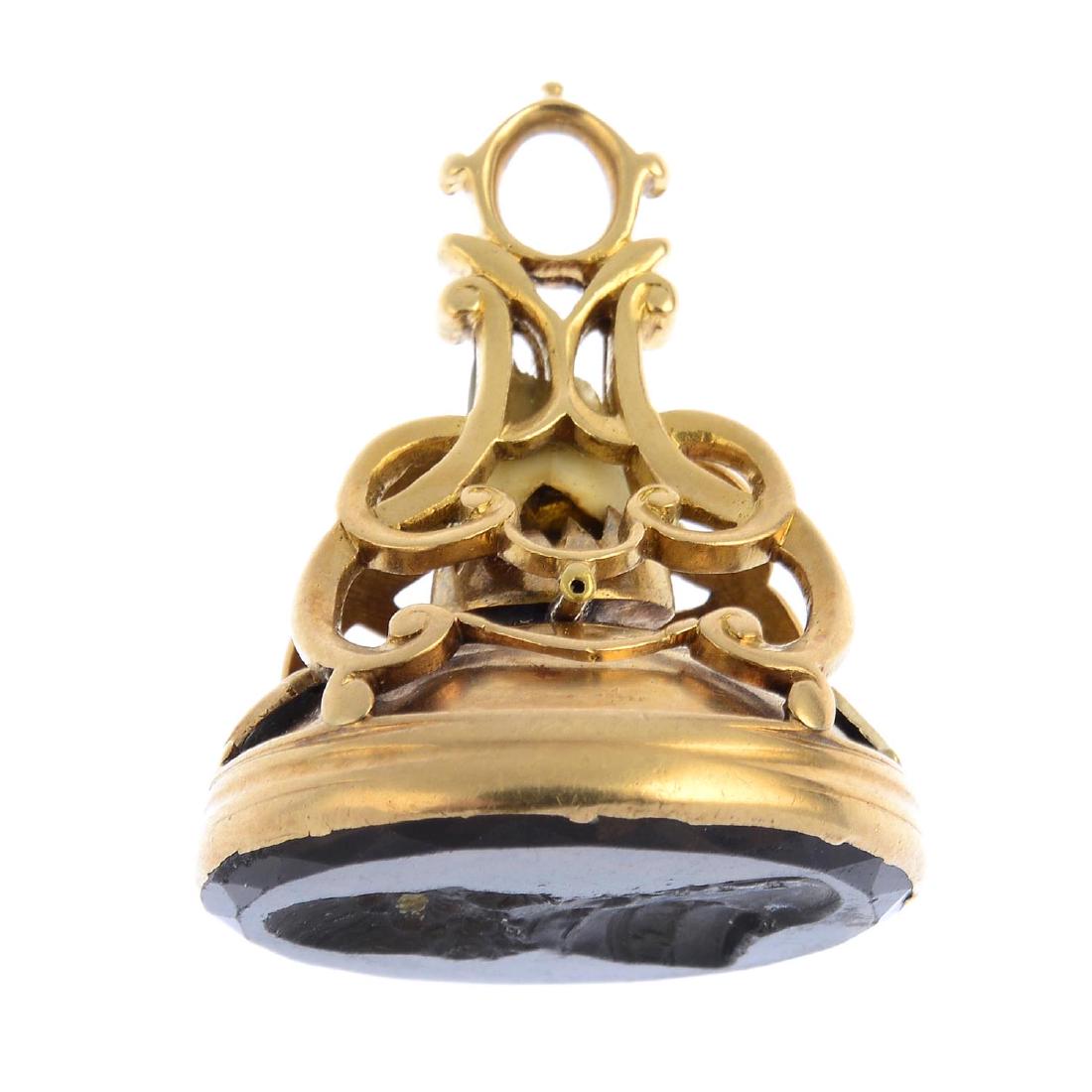 A mid 19th century gold, smokey quartz and tooth: A mid 19th century gold, smokey quartz and tooth intaglio seal fob. The oval smokey quartz, carved to depict a gentleman in profile, to the shell and interlaced scroll pedestal enclosing a tooth. Leng