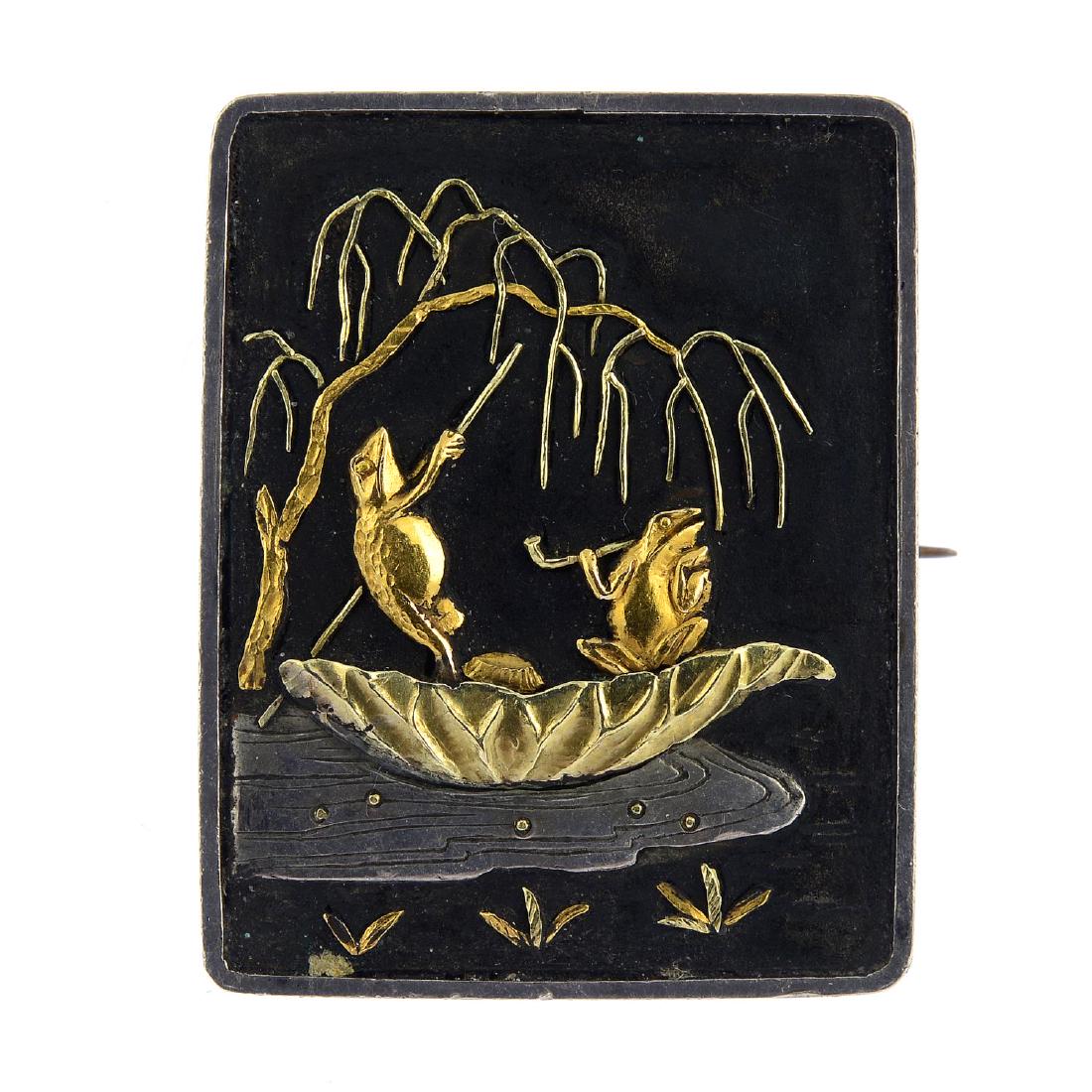 A Shakudo brooch. Of tri-colour design, the rectangular: A Shakudo brooch. Of tri-colour design, the rectangular panel depicting two frogs punting under a willow tree, one smoking. Length 2.8cms.