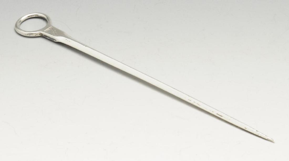 A George III Irish silver meat skewer, of typical: A George III Irish silver meat skewer, of typical tapering form with engraved crest below the circular ring handle. Hallmarked Dublin 1815, maker's mark 'IS' in a rectangular punch. Length measuring 7