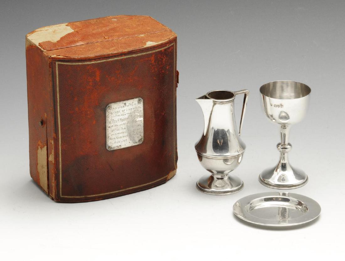An early twentieth century silver travelling communion: An early twentieth century silver travelling communion set, including a chalice, paten and flagon (missing lid), each of plain circular form, contained within a fitted case with applied silver present