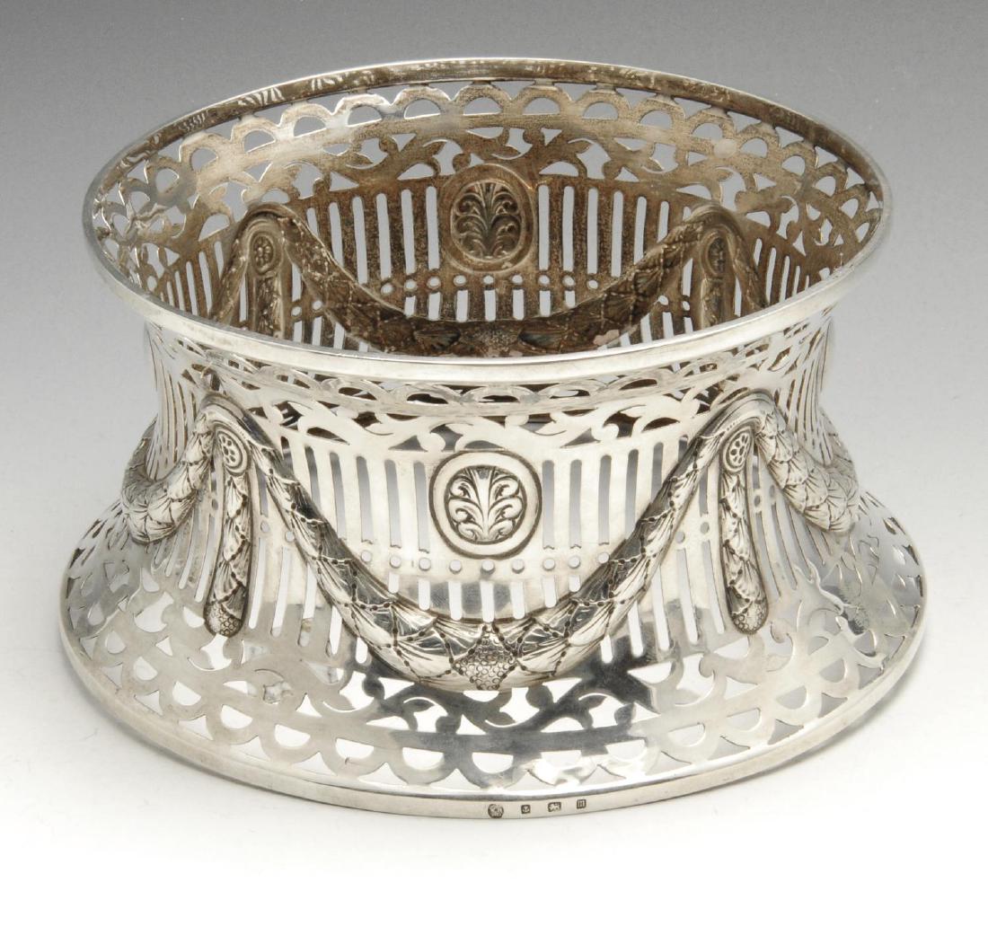 An early twentieth century silver dish ring, the: An early twentieth century silver dish ring, the foliate and vertical pierced sides overlaid with swag and pendant motifs. Hallmarked Williams (Birmingham) Ltd., Birmingham 1911. Base diameter measuri