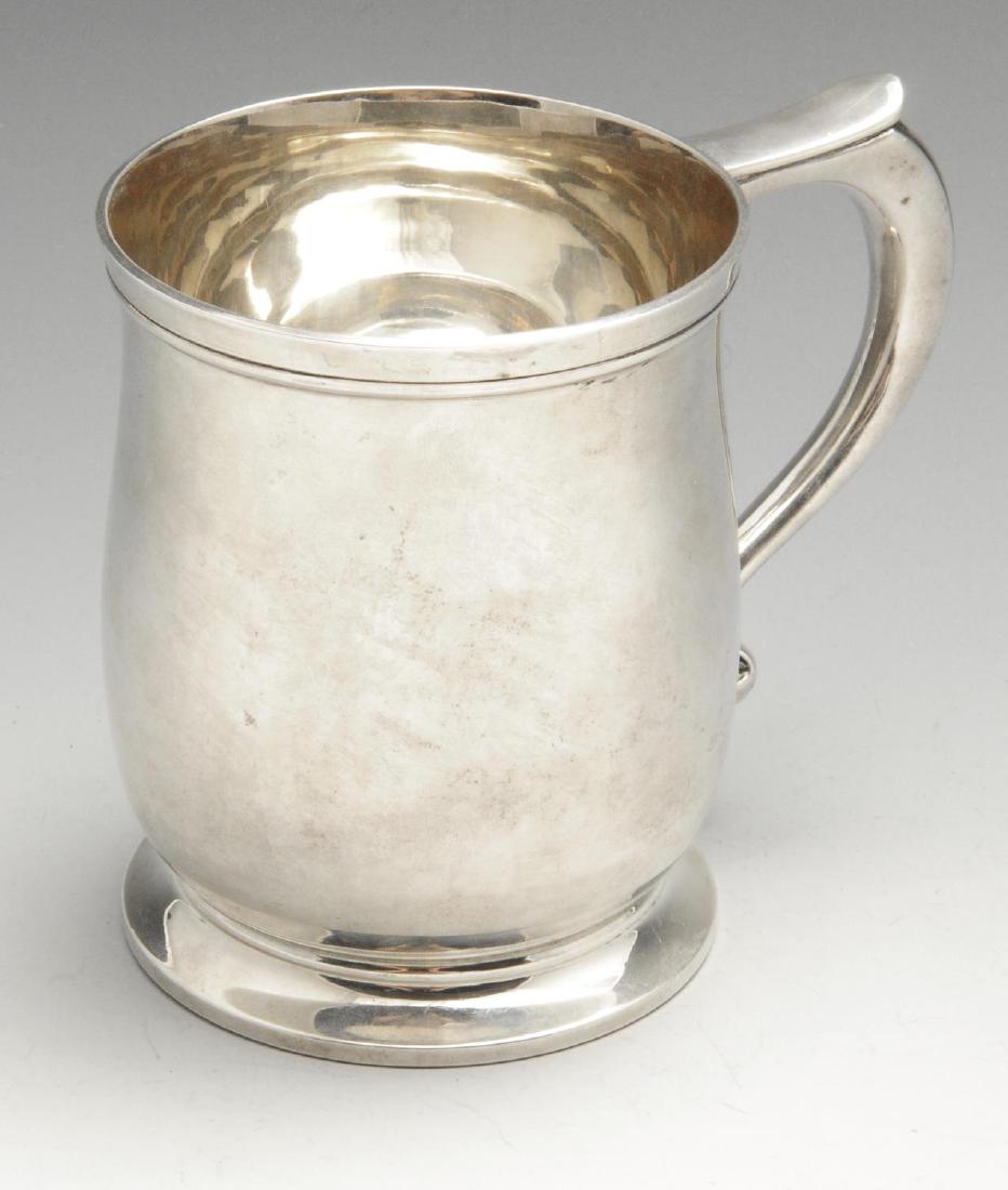 A mid-twentieth century silver pint mug, of plain: A mid-twentieth century silver pint mug, of plain baluster form to a footed base, and scroll handle. Hallmarked Mappin & Webb Ltd., Sheffield 1950. Height measuring 4 3/8 inches (11.2 cm), weight 10.1