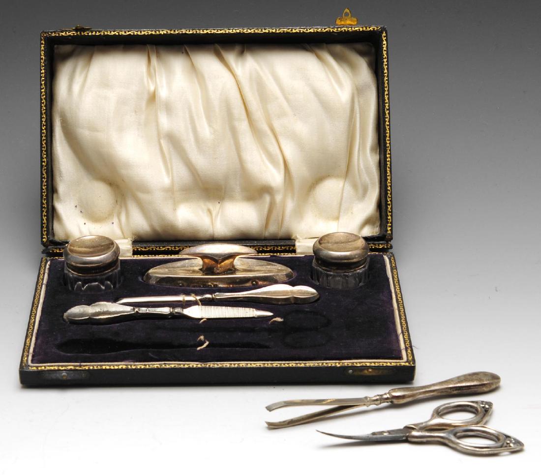 A 1920's part manicure set, including a silver mounted: A 1920's part manicure set, including a silver mounted nail buffer, a pair of silver lidded vanity pots, a silver handled nail file and a silver handled cuticle tool, contained within a fitted case (t