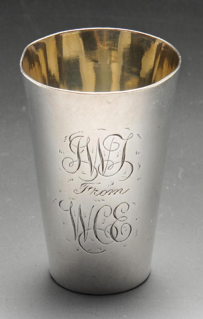 A late Victorian silver shot cup, of plain tapered form: A late Victorian silver shot cup, of plain tapered form with two engraved monograms and inset coin to the base, hallmarked Henry Stratford Ltd., Sheffield 1890, height measuring 2 1/2 inches (6.7 cm).