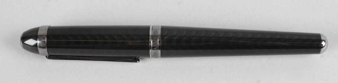 A Tibaldi for Giorgio Armani 'Regal' limited edition: A Tibaldi for Giorgio Armani 'Regal' limited edition rollerball pen, the black translucent layered enamel body with rippled effect, having gunmetal clip and banding stamped 191/199, the twist action c