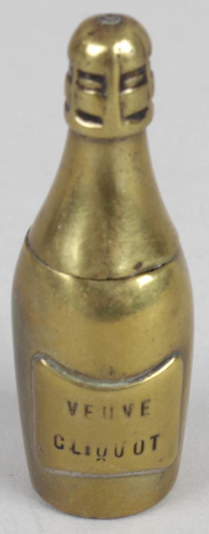 A late Victorian novelty base metal vest case, modelled: A late Victorian novelty base metal vest case, modelled as a champagne bottle with hinged opening cover, 2.25 (5.5cm) high.