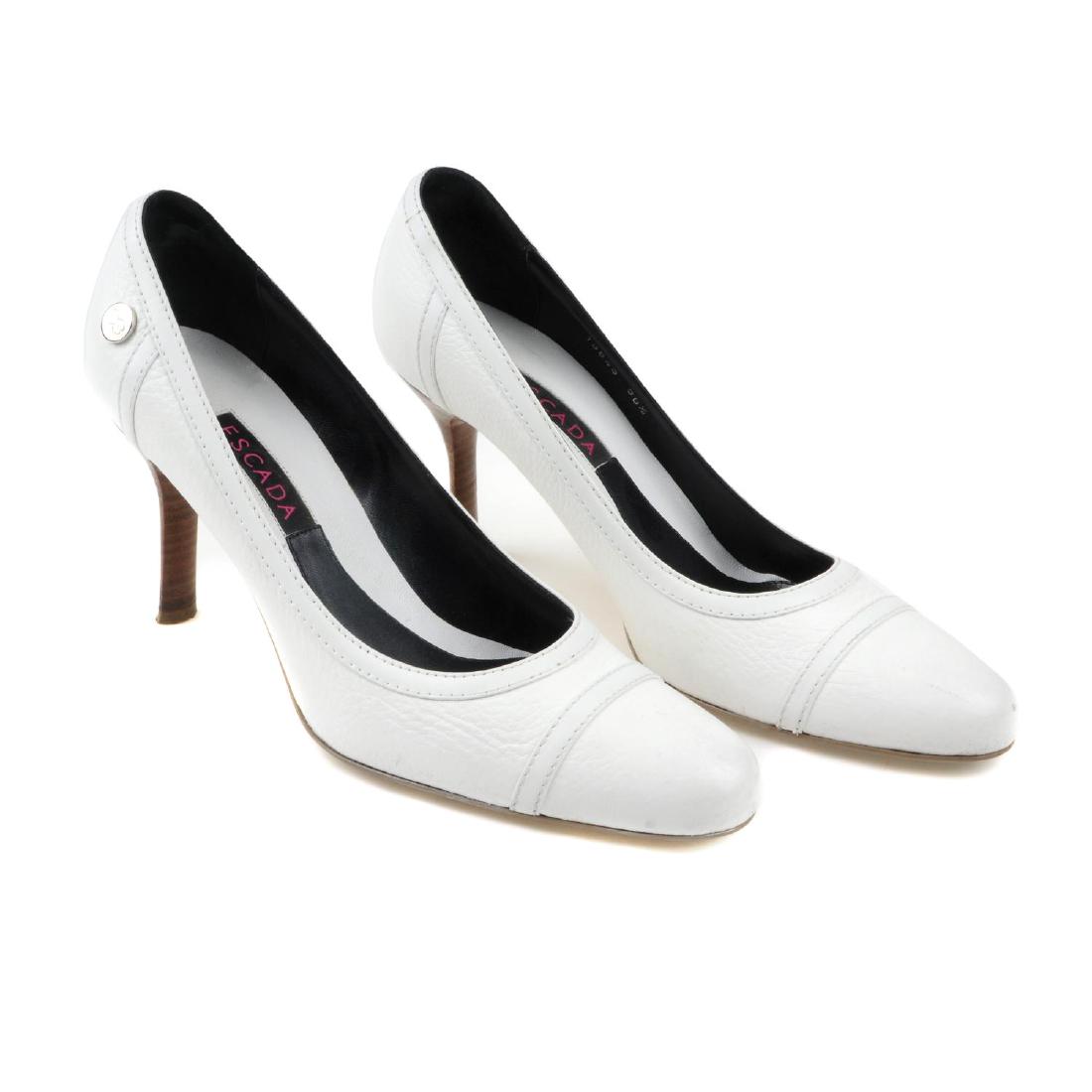 ESCADA - a pair of heeled pumps. Crafted from white: ESCADA - a pair of heeled pumps. Crafted from white leather with thin wooden stiletto heels. Labelled Escada, size 36.5. With maker's dust bags and box.