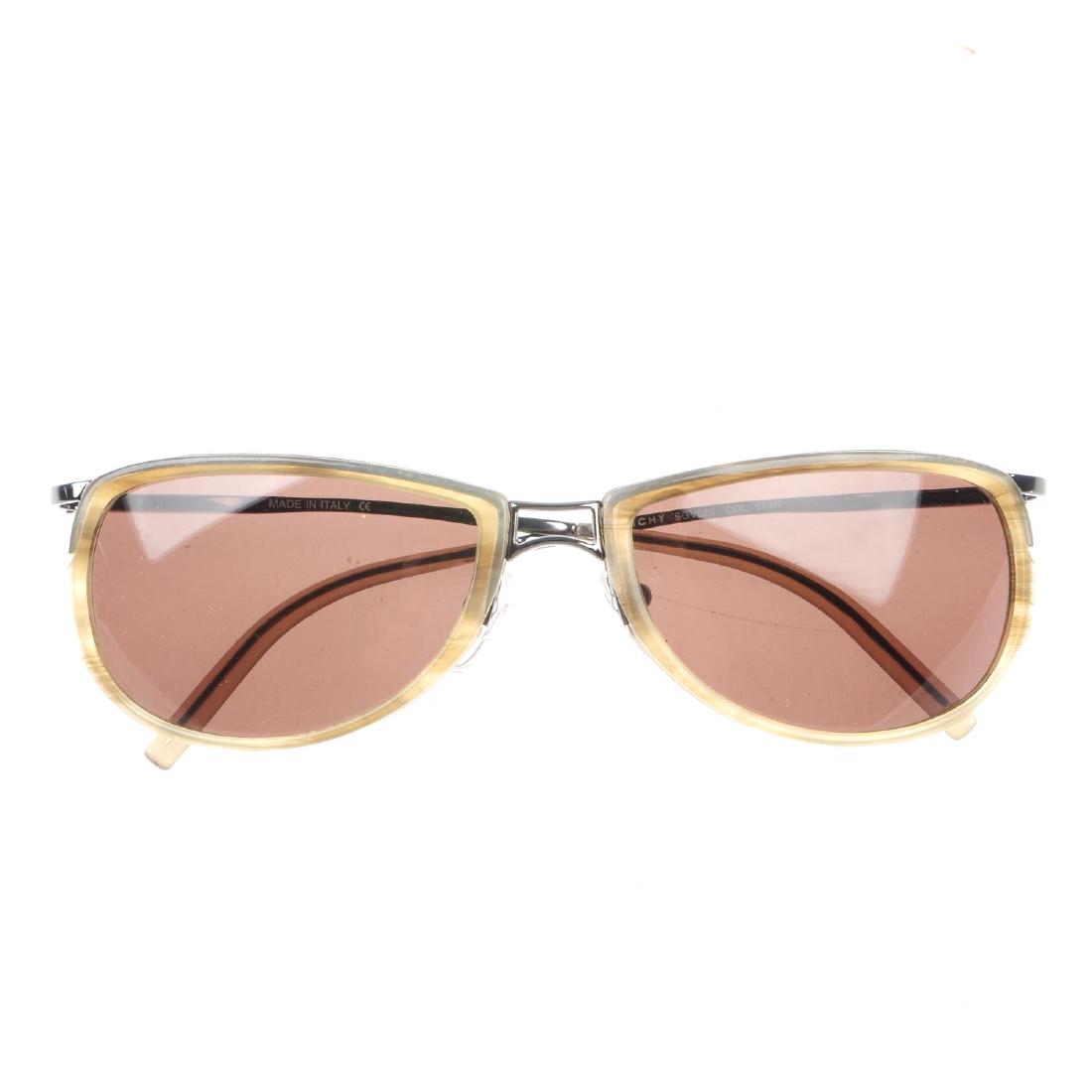 GIVENCHY - a pair of sunglasses. Featuring brown tinted: GIVENCHY - a pair of sunglasses. Featuring brown tinted oval lenses, with cream acetate rims, gunmetal wire frames and maker's name to the left side temple. With maker's cleaning cloth and case.