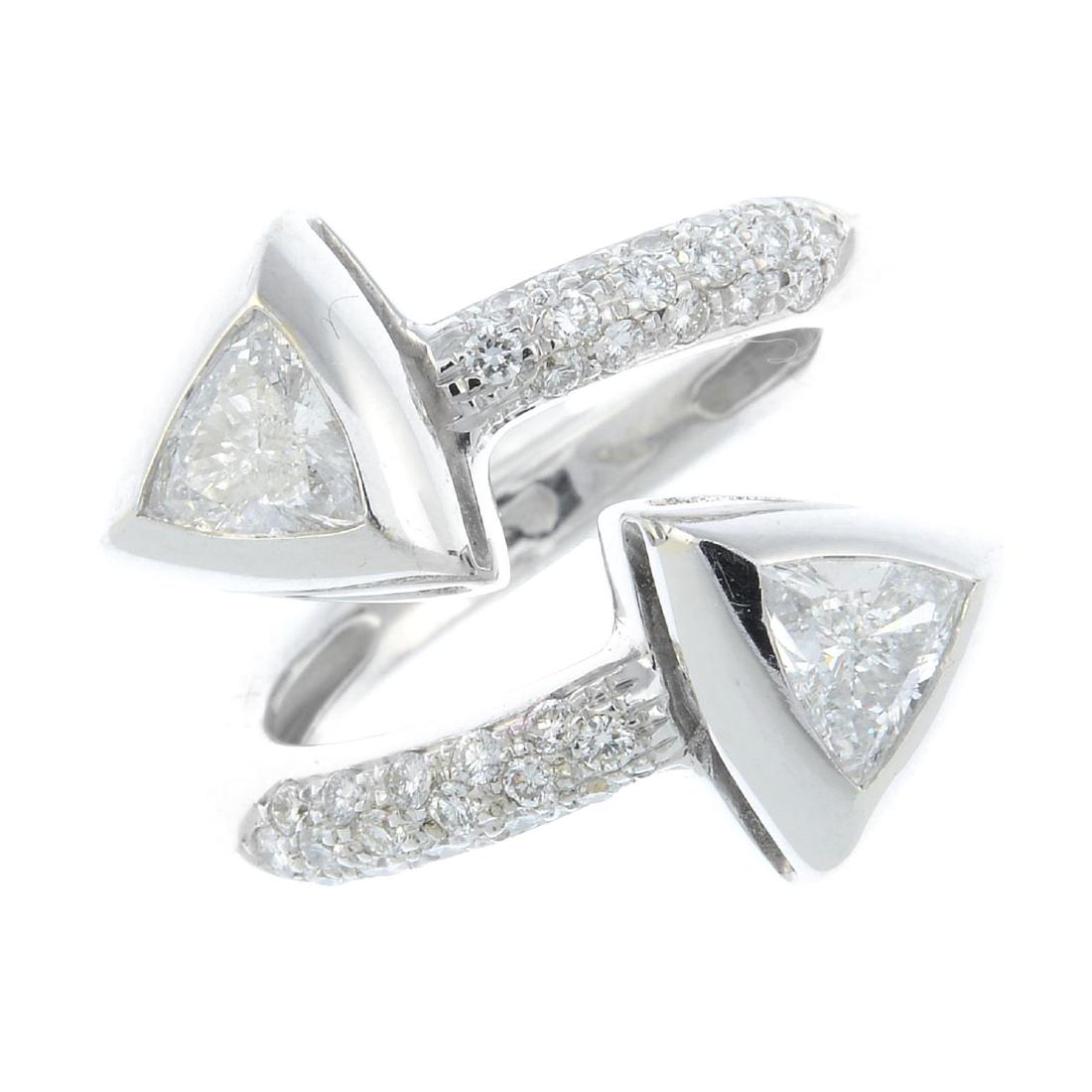 A diamond two-stone ring. The open band, with: An 18ct gold diamond two-stone ring. The open band, with triangular-shape diamond collet terminals, to the pave-set diamond asymmetric shoulders. Signed Antonini. Estimated total diamond weight 1.30ct