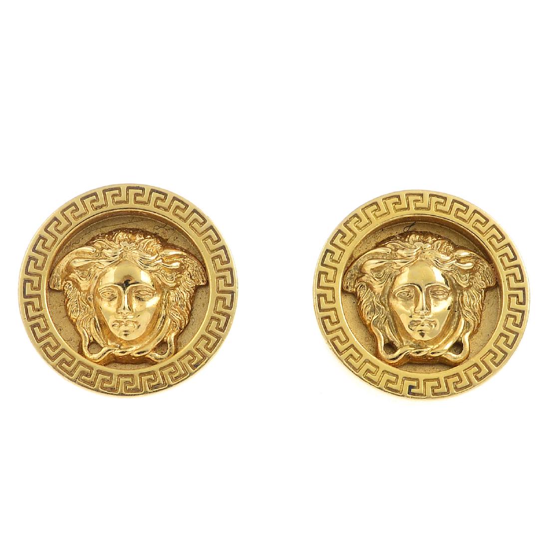 VERSACE - a pair of 18ct gold 'Medusa' earrings. Each: VERSACE - a pair of 18ct gold 'Medusa' earrings. Each designed as a Medusa mask, with Greek-key raised circular surround. Signed Gianni Versace, No 020. Hallmarks for Birmingham. Diameter 1.5cms. Weig