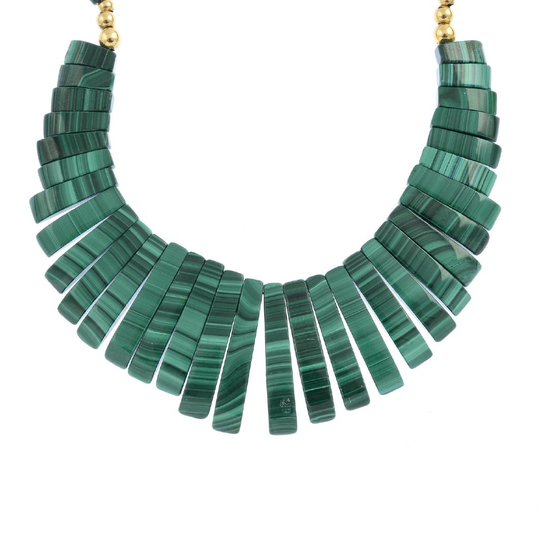 A malachite necklace. The graduated, curved bar fringe,: A malachite necklace. The graduated, curved bar fringe, suspended from a cylindrical malachite bead back-chain with bead spacers. Length 50cms.