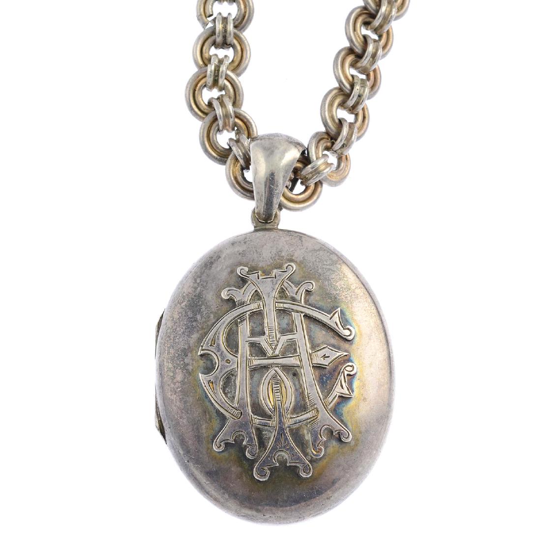 A late Victorian silver locket. Of oval outline, with (1 of 2)