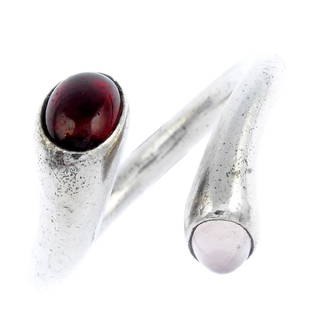 GEORG JENSEN - a silver garnet and rose quartz: GEORG JENSEN - a silver garnet and rose quartz 'Carnival' ring. The open band, with oval garnet and rose quartz cabochon asymmetric terminals. Designed by Regitze Overgaard. Maker's mark for Georg Jen