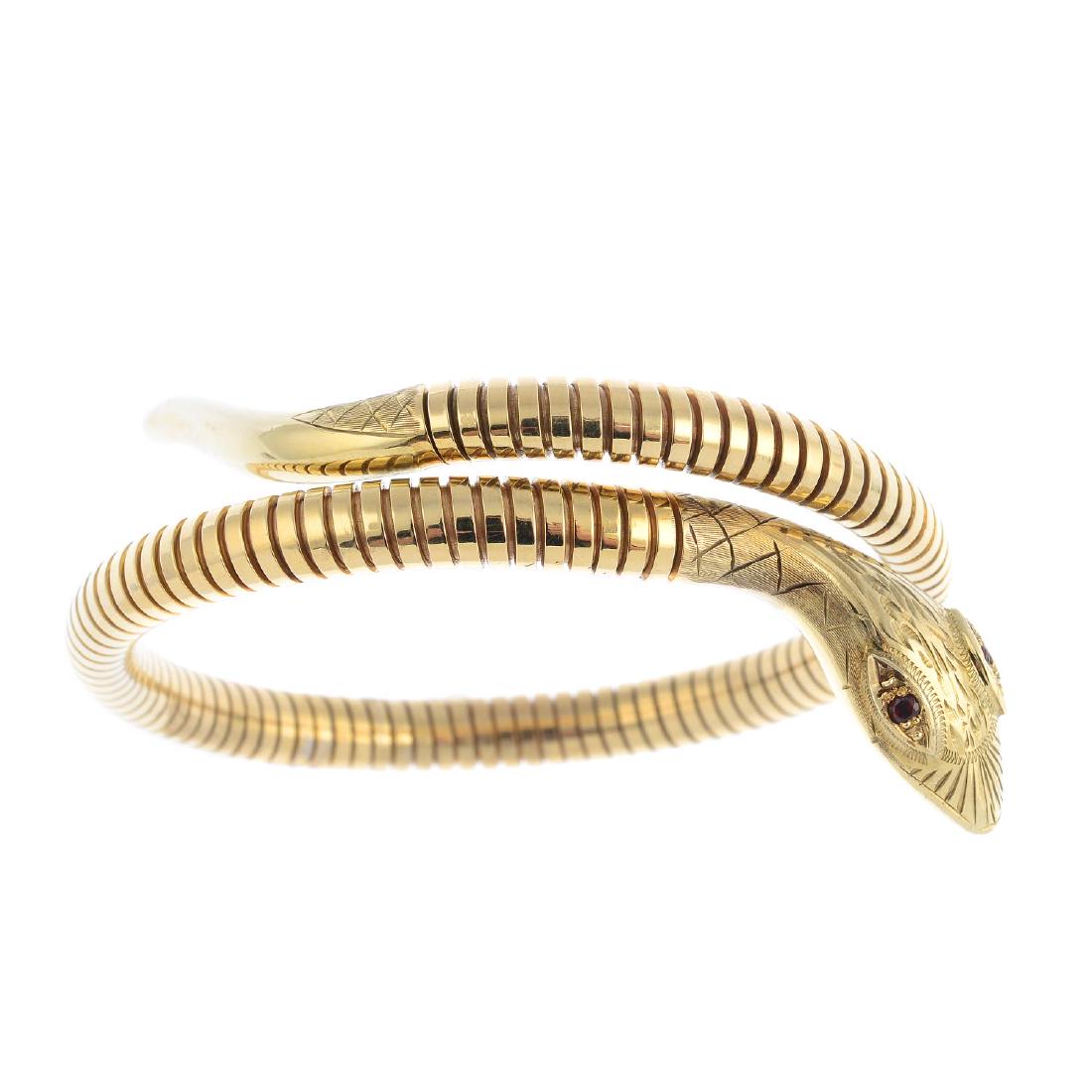 A 9ct gold gem-set flexible snake bangle. Designed as a (1 of 2)
