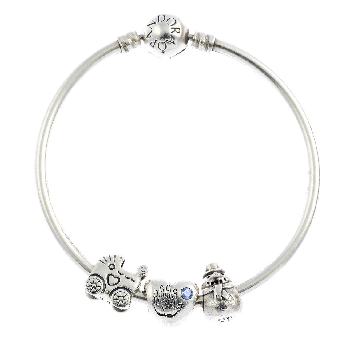 PANDORA - three bracelets. To include two snake-link: PANDORA - three bracelets. To include two snake-link bracelets, one suspending four charms, together with a solid bangle suspending three charms. Maker's marks for Pandora. Inner diameter 5.5 to 6.3cm