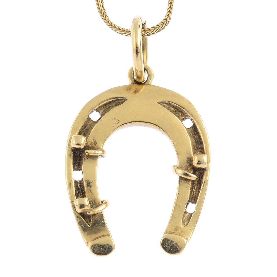 A 9ct gold horseshoe pendant. Of openwork design, the (1 of 2)