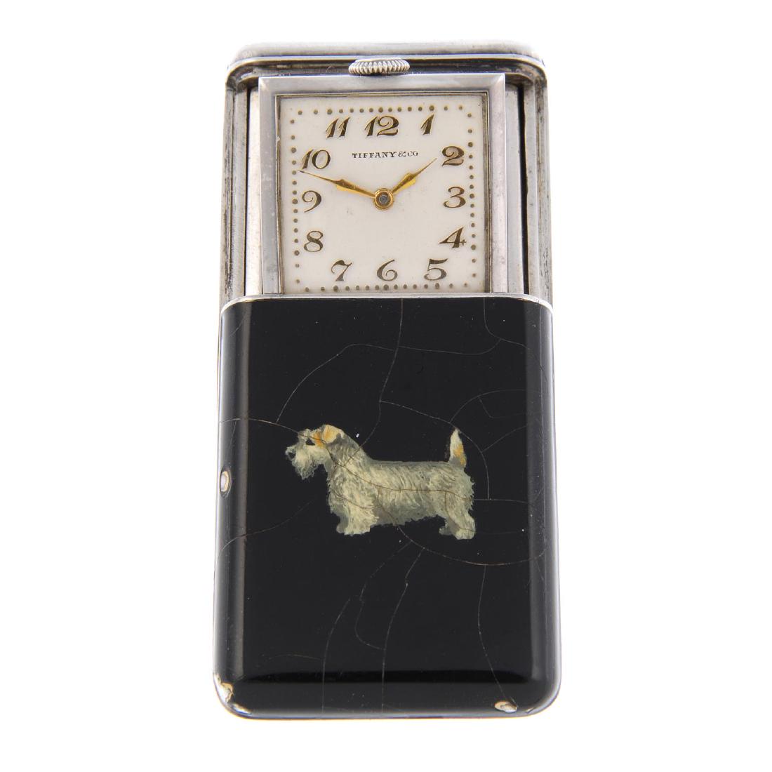 A purse watch by Tiffany & Co. Silver case with: A purse watch by Tiffany & Co. Silver case with enamelled dog to case front. Numbered 2171. Manual wind movement, signed Cresarrow Watch Co. Silvered dial with Arabic numeral hour markers. 31mm.