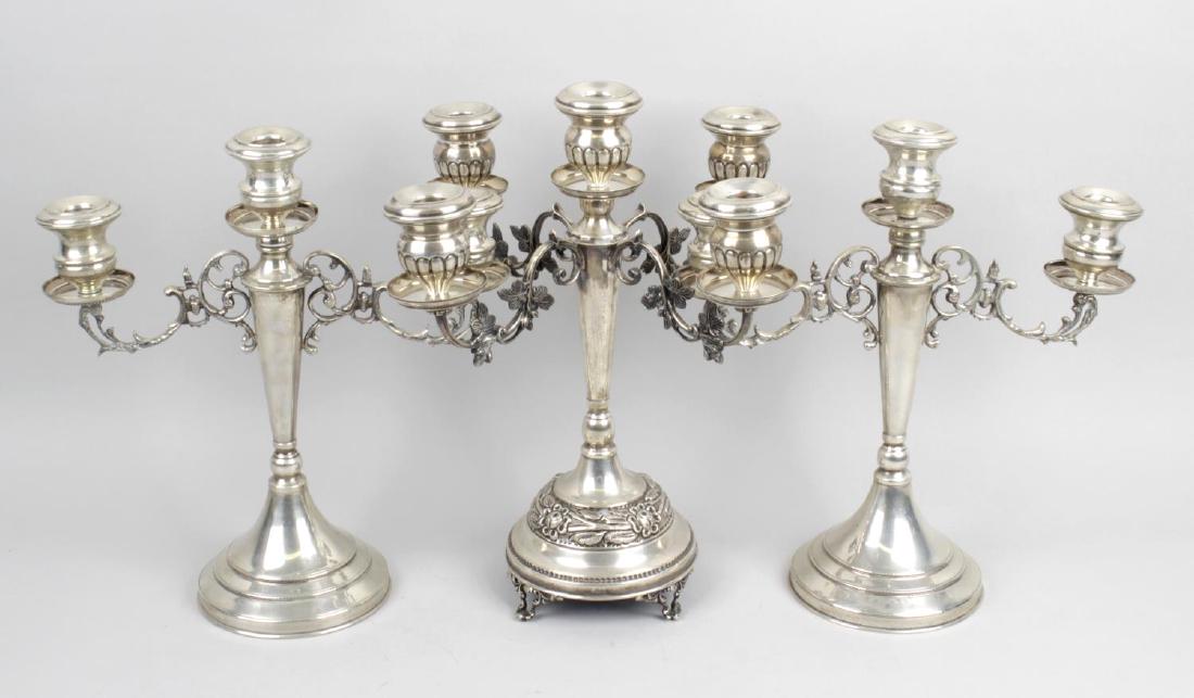 A pair of twentieth century 925 sterling silver: A pair of twentieth century 925 sterling silver candelabra, the pierced and scroll twin branches upon a central tapered column support and filled circular stepped bases, stamped marks 925, 12 (30.5cm)