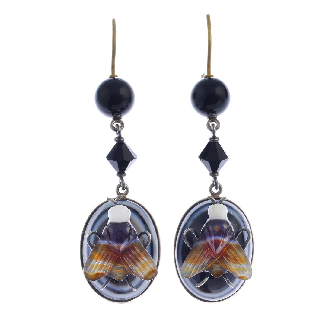 A pair of banded agate and onyx earrings. Each designed: A pair of banded agate and onyx earrings. Each designed as a banded agate fly, atop an oval banded agate cabochon collet, suspended from an onyx bead surmount, with faceted onyx bead spacer. Length 6.