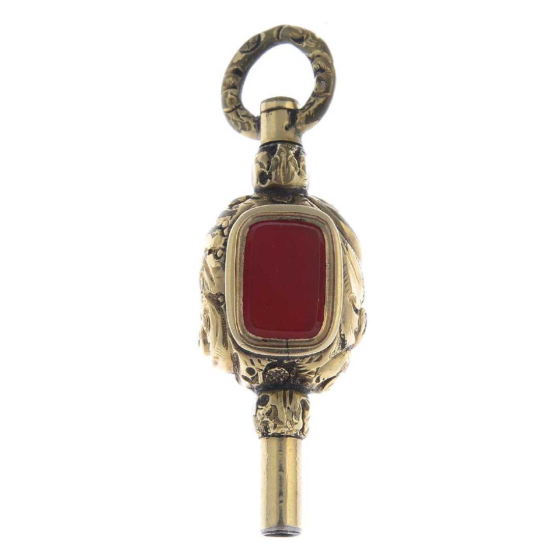 A carnelian watch key. Of scrolling foliate motif, with: A carnelian watch key. Of scrolling foliate motif, with rectangular carnelian and white chalcedony panels. Length 3.9cms. Total weight 4.9gms.