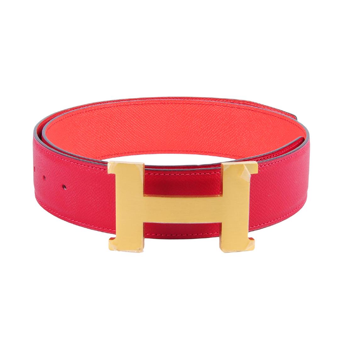 HERMÈS - a reversible logo buckle belt. Designed with: HERMÈS - a reversible logo buckle belt. Designed with grained red leather to one side and grained coral pink leather to the reverse side, featuring maker's gold-tone detachable 'H' buckle fastening.