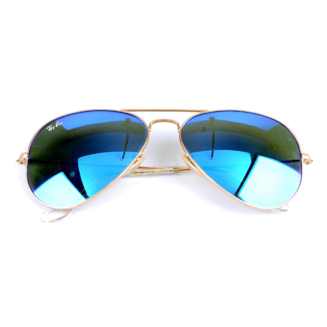 RAY BAN - a pair of Aviator Flash sunglasses. Featuring: RAY BAN - a pair of Aviator Flash sunglasses. Featuring blue violet reflective lenses of the classic rounded aviator design with thin matte gold-tone frames and clear ear pieces. With maker's case.