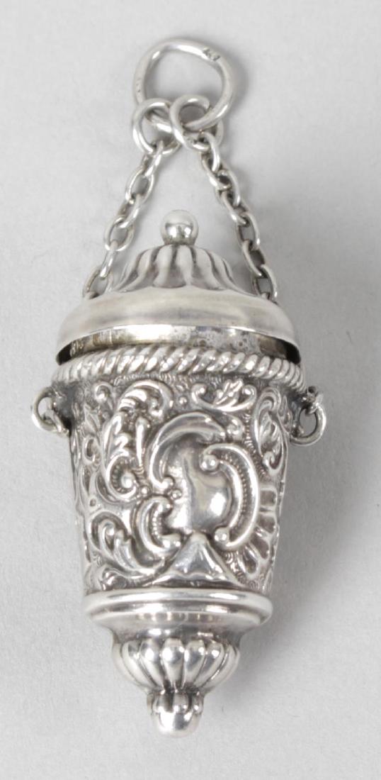 A late Victorian silver thimble holder, embossed with: A late Victorian silver thimble holder, embossed with foliate scrolls and the hinged lid opening to a gilt interior, on suspension chain and loop. Hallmarked Henry Matthews, Birmingham 1898. Height 4.