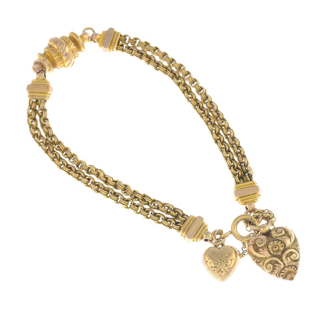 A late 19th century bracelet, with a 9ct gold: A late 19th century bracelet, with a 9ct gold heart-shape charm. Designed as a textured cylinder, with fancy-link double chain and polished spacers, suspending a later 9ct gold heart-shape charm, with