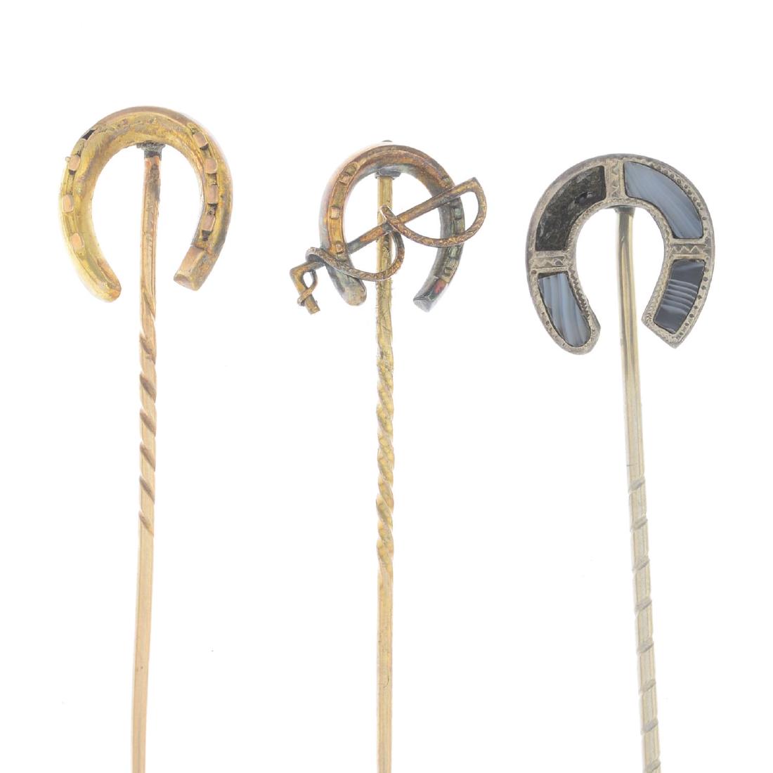 Eleven horseshoe stick pins. To include two split pearl: Eleven horseshoe stick pins. To include two split pearl examples, one with riding crop and one floral example. Four with marks to indicate gold. Total weight 11.5gms.