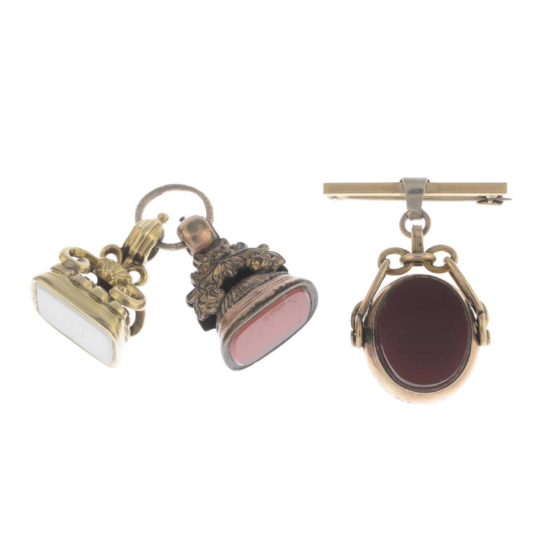 Three late Victorian fobs. To include a rotating: Three late Victorian fobs. To include a rotating oval-shape carnelian and bloodstone panel, suspended from a fancy-link chain and bar brooch, together with a carnelian and chrysoprase fob, each with f