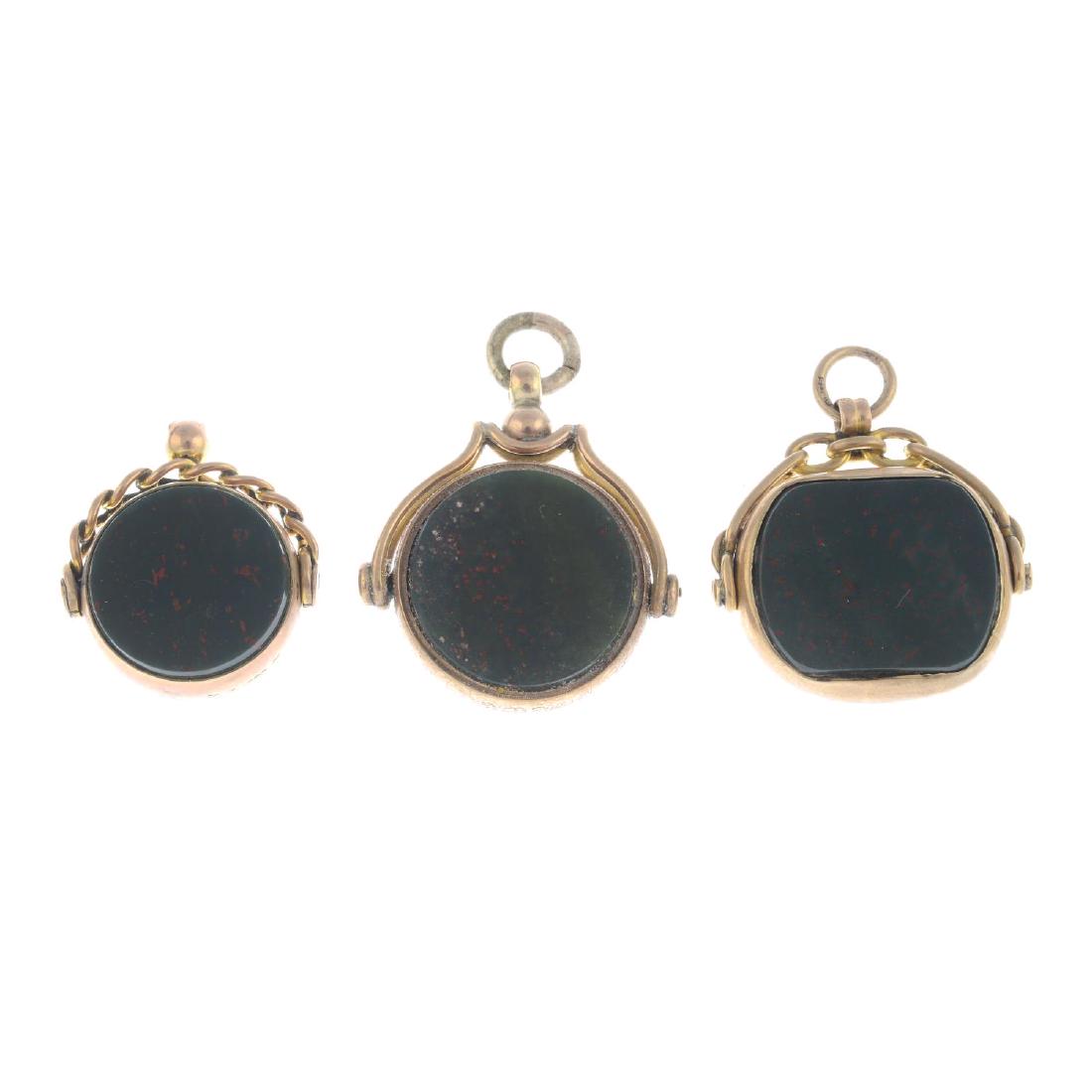 Three early 20th century 9ct gold bloodstone and: Three early 20th century 9ct gold bloodstone and carnelian fobs. The first two designed as a circular-shape bloodstone, rotating to the carnelian reverse, suspended from variously designed surmount, t