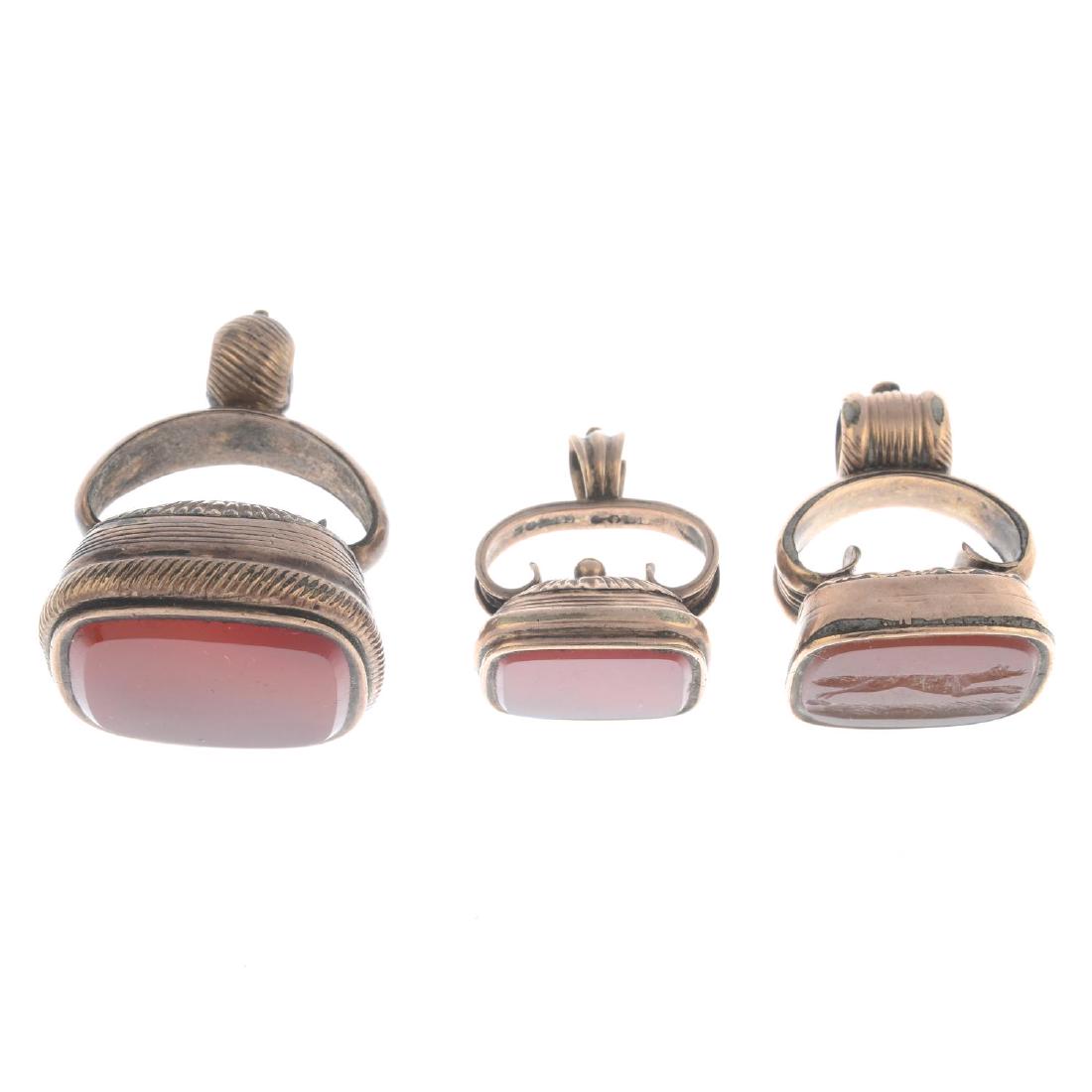 Three carnelian fobs. Each designed as a: Three carnelian fobs. Each designed as a rectangular-shape carnelian, suspended from a scrolling pedestal and hoop surmount. Lengths 2.3 to 3.3cms. Weight 27gms.