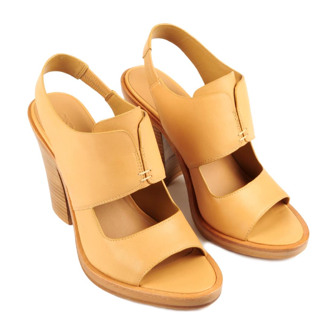 DKNY - a pair of sling back heeled sandals. Crafted: DKNY - a pair of sling back heeled sandals. Crafted from nude leather, featuring an open toe, elasticated sling back strap and a wide block heel. Labelled DKNY. Size 5.5. With maker's box.