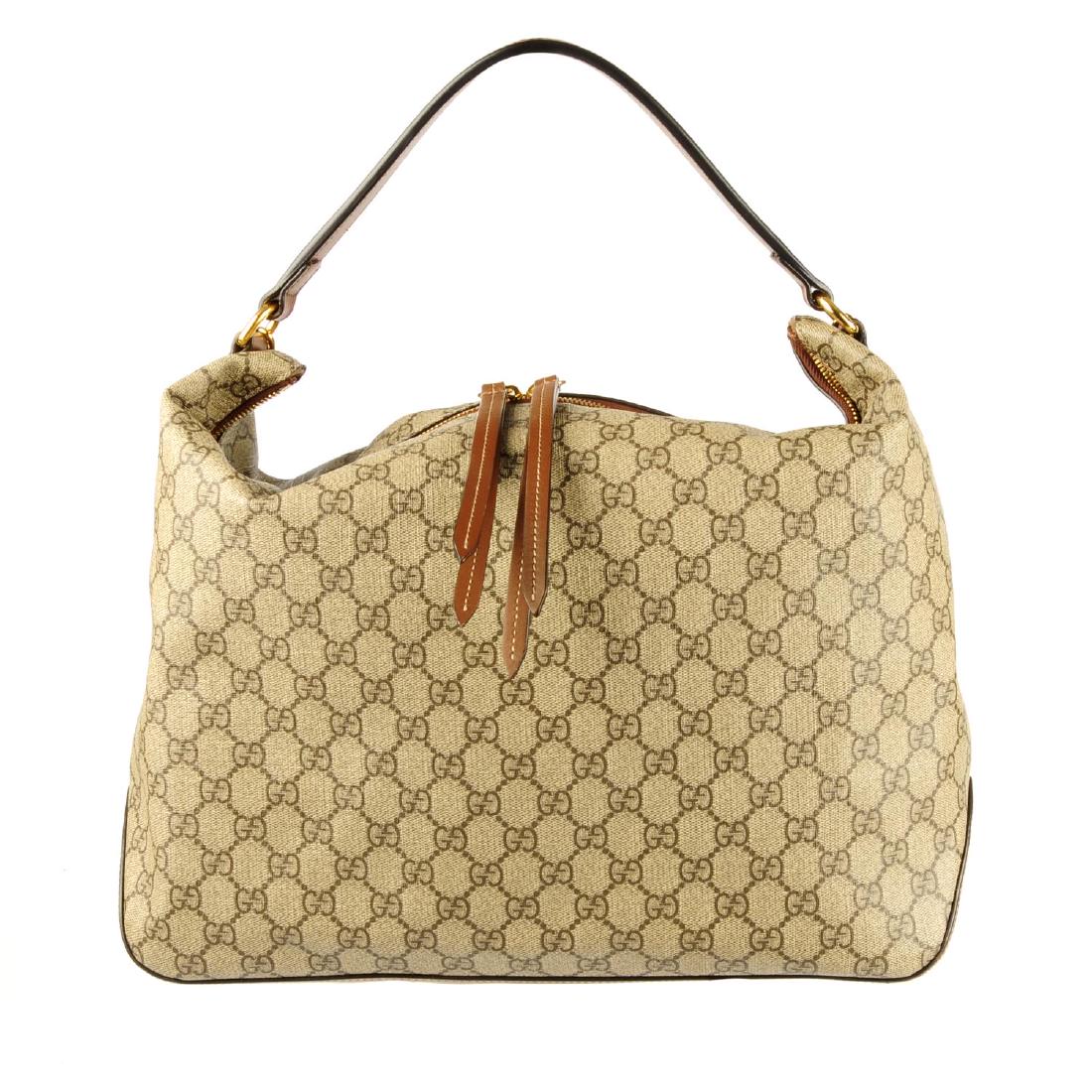 GUCCI - a Supreme hobo handbag. Designed with maker's: GUCCI - a Supreme hobo handbag. Designed with maker's monogram coated canvas exterior with tan leather trim, featuring a flat leather handle and a gold-tone chain shoulder strap, top zip fastening and