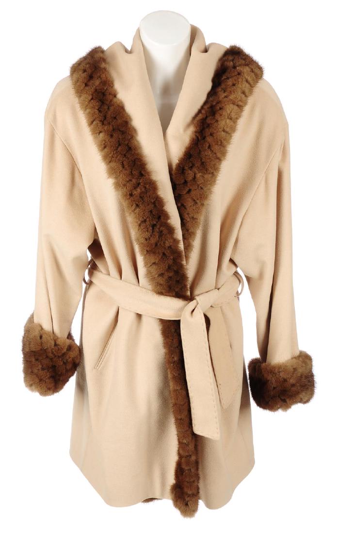 A cream hooded jacket with mink fur trim. The wool,: A cream hooded jacket with mink fur trim. The wool, angora and cashmere blend jacket, with belted waist and demi-buff mink fur trim. Labelled Jan-Rone Paris. Chest measures approximately 50inches.