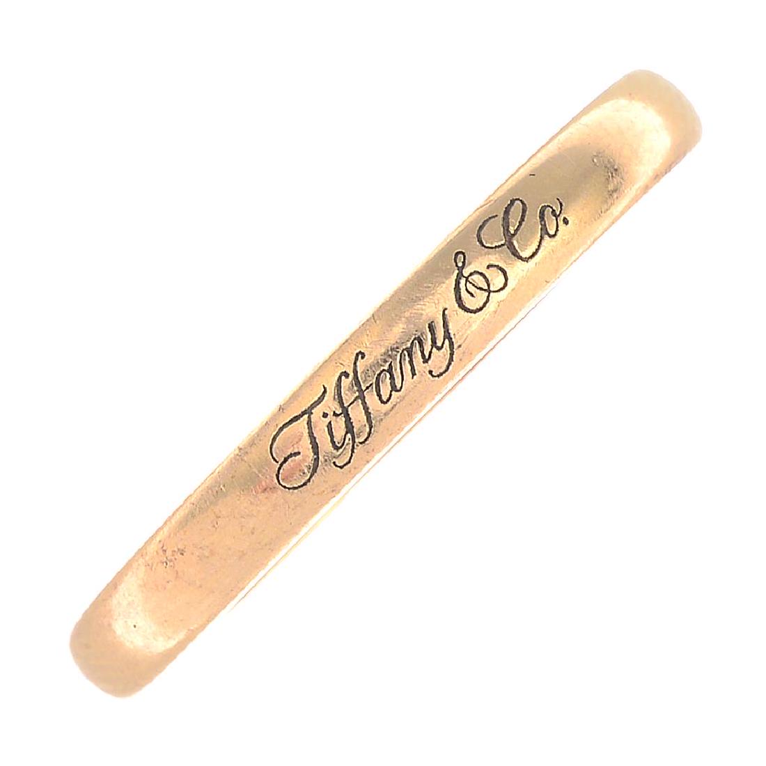 TIFFANY & CO. - a band ring. Signed Tiffany & Co.: TIFFANY & CO. - a band ring. Signed Tiffany & Co. Stamped 750. Ring size T. Width 0.3cm. Weight 3.7gms.