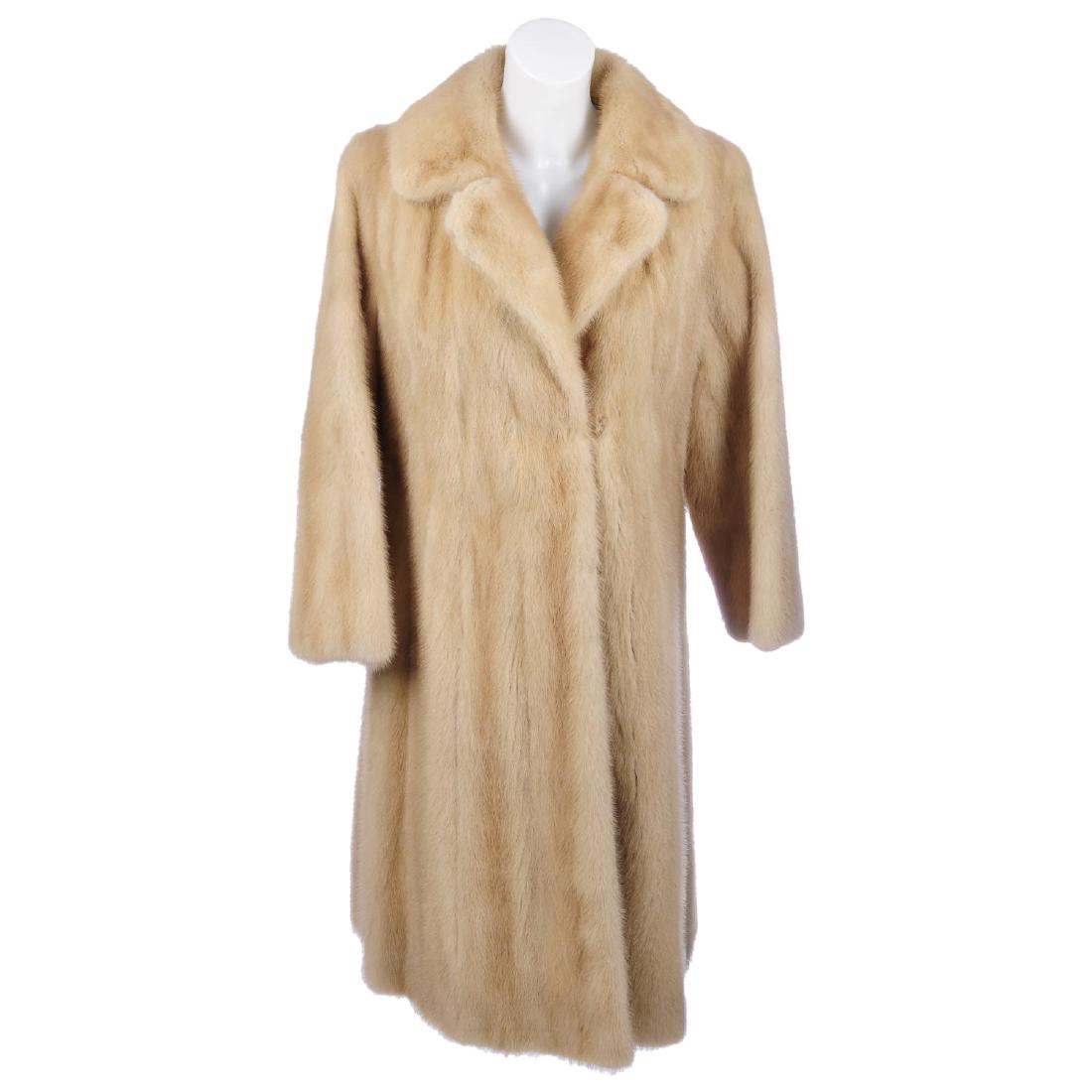 A knee-length palomino mink coat. Designed with a (1 of 2)