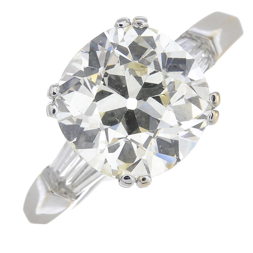 An old-cut diamond single-stone ring, with tapered: An old-cut diamond single-stone ring, with tapered baguette-cut diamond sides.Principal diamond estimated weight 3.25cts, L-tinted colour, SI clarity.Stamped K18. Ring size M1/2. 5.6gms.