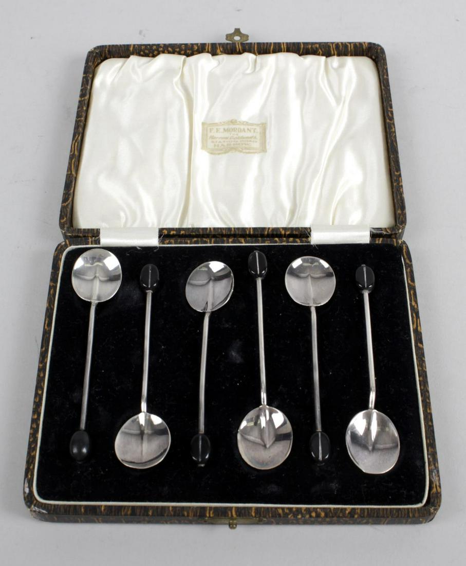 A cased set of six 1920's silver coffee spoons with: A cased set of six 1920's silver coffee spoons with coffee bean terminals, hallmarked Adie Brothers Ltd, Birmingham 1928, together with a cased matched egg cup set, comprising egg cup, spoon and napki