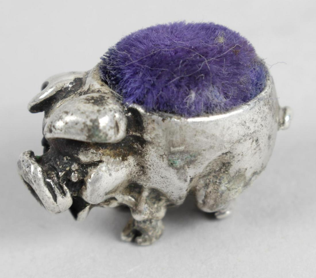 A miniature silver mounted pin cushion, modelled in the: A miniature silver mounted pin cushion, modelled in the form of a pig standing on all fours. Hallmarked London 1994, also marked 925 with the Common Control mark. Length 2.5 cm.