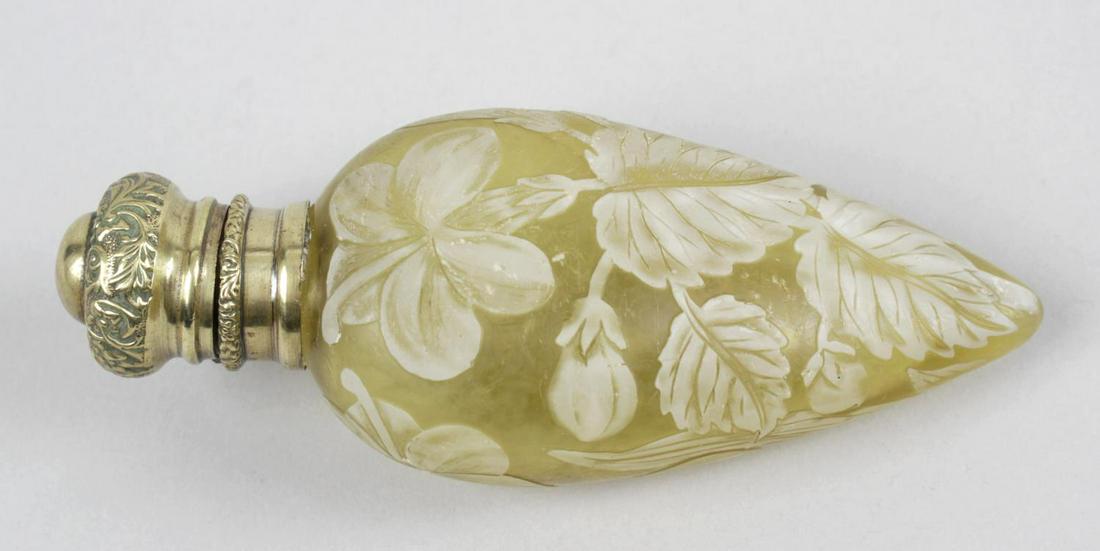 A Victorian yellow cameo glass scent bottle in the: A Victorian yellow cameo glass scent bottle in the manner of Thomas Webb & Sons, the body of teardrop form with white floral overlaid decoration, the base metal mounted hinged cover with embossed foli