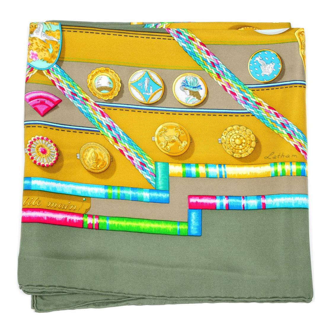 HERMÈS - a 'Petit Main' silk scarf. Designed by Cathy: HERMÈS - a 'Petit Main' silk scarf. Designed by Cathy Latham, first issued in 1987, featuring a multicoloured haberdashery design with thread, buttons and chatelaines on an olive green background. Me