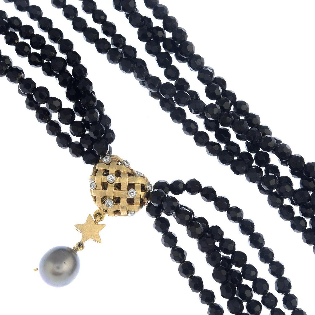 An onyx four-strand necklace, with diamond and grey: An onyx four-strand necklace, with diamond and grey cultured pearl heart and star clasp, by Charlotte Lynggaard for Ole Lynggaard.Estimated total diamond weight 0.35ct.Stamped 585. Length 35.5cms. Wei