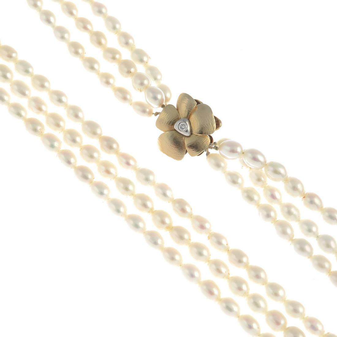 A freshwater cultured pearl three-strand necklace, with: A freshwater cultured pearl three-strand necklace, with diamond floral clasp, by Charlotte Lynggaard for Ole Lynggaard.Total diamond weight 0.06ct, marked to clasp.Stamped 585. Length 49cms. Weight of