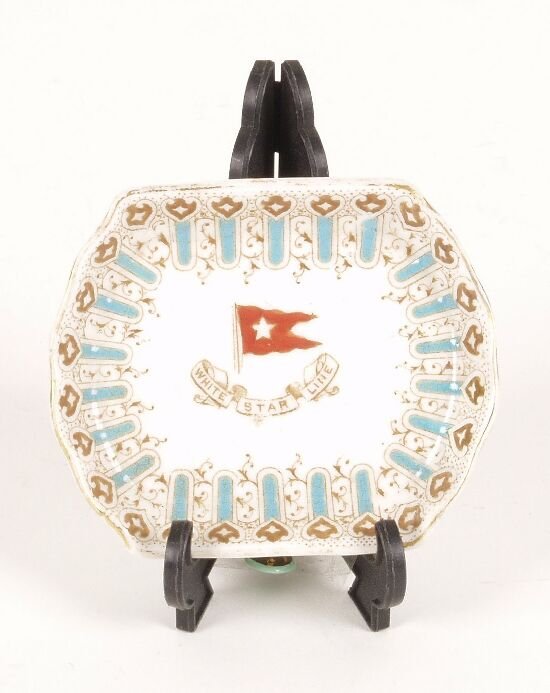 An early 20th century bone china 'Pin di: An early 20th century bone china 'Pin dish' of scalloped outline decorated with a blue and gilt border, the plain central reserve with a White Star shipping line crest.