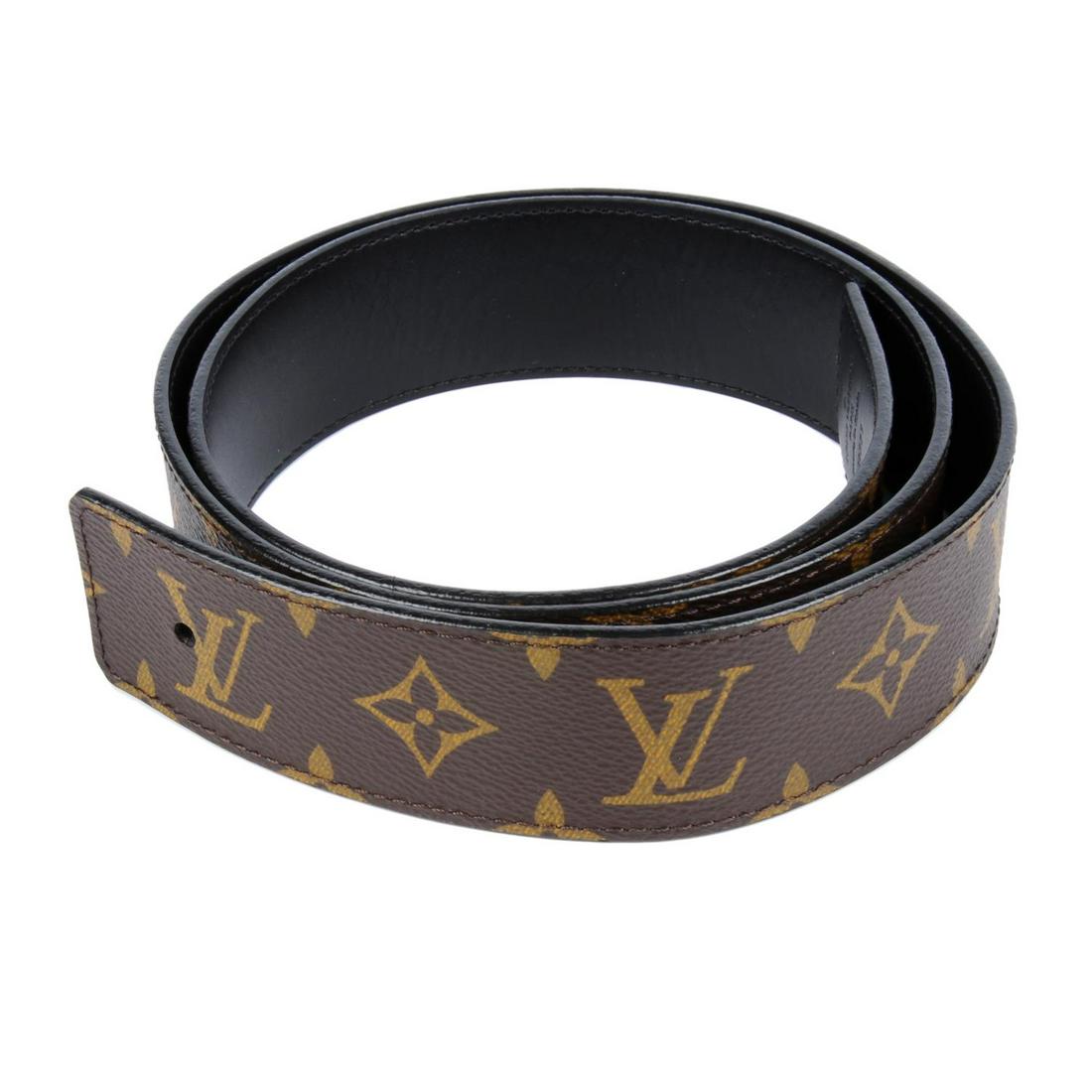 LOUIS VUITTON - a Monogram belt. Featuring a brown: LOUIS VUITTON - a Monogram belt. Featuring a brown monogram coated canvas exterior and black leather underside. Deficient of buckle. Stamped Louis Vuitton, size 95/38.
