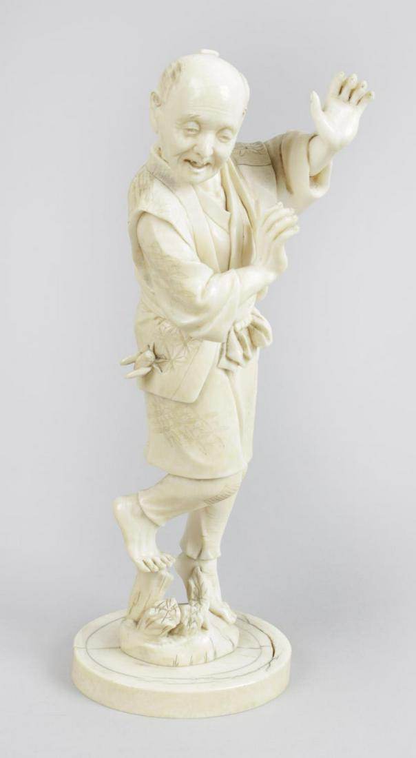 A 19th century carved ivory okimono, modelled as an: A 19th century carved ivory okimono, modelled as an aged standing male, with arms raised in startled pose, with cricket upon the top of his leg, upon naturalistic modelled base, with impressed red sea