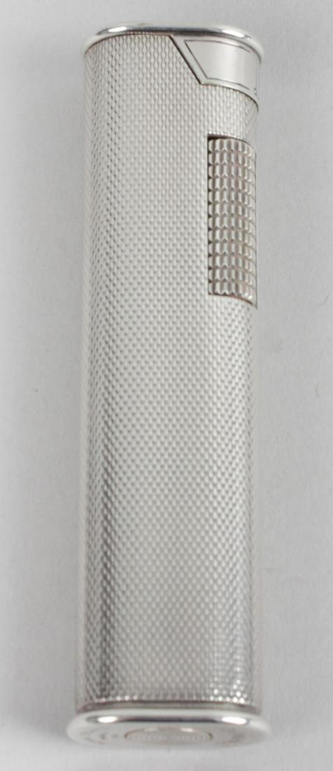 A silver Dunhill cigarette lighter, of slender form: A silver Dunhill cigarette lighter, of slender form with rounded sides and engine turned decoration to the whole, 3 (7.5cm) high.